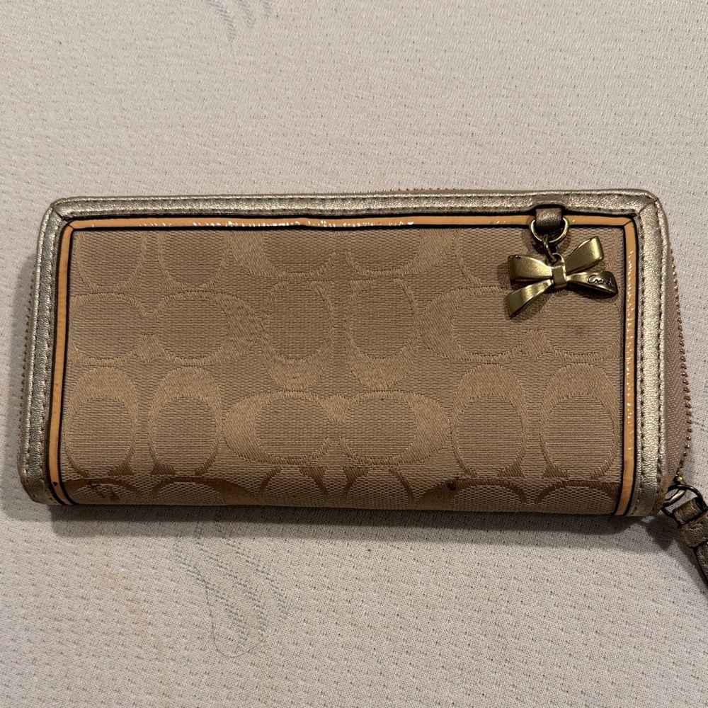 COACH long zip around wallet. Canvas w/ logo & metallic trim. Bow charm